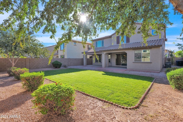 back of property with a lawn and a patio area