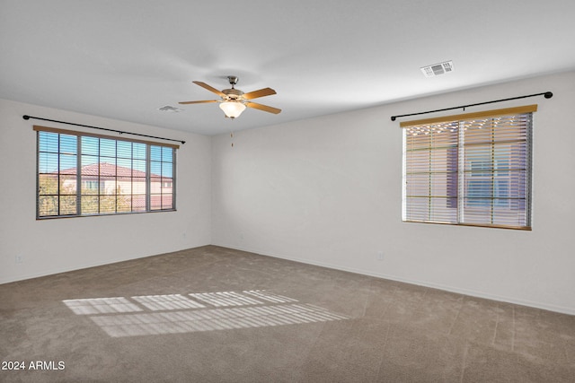 carpeted spare room featuring ceiling fan