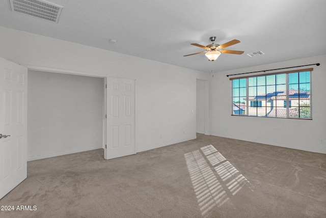 unfurnished room featuring ceiling fan and light carpet