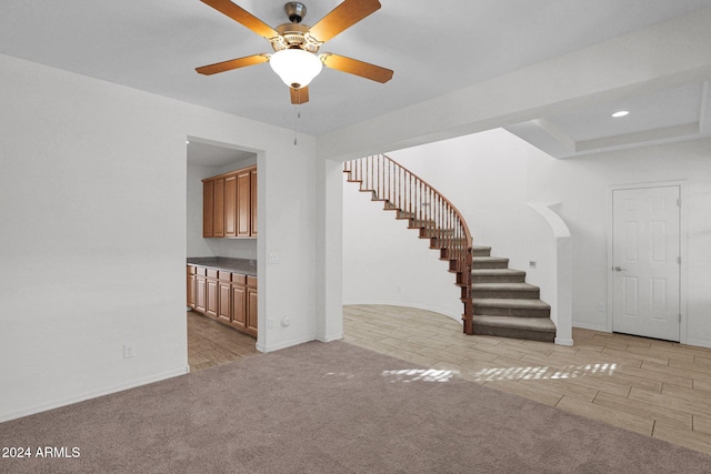 interior space with light colored carpet and ceiling fan