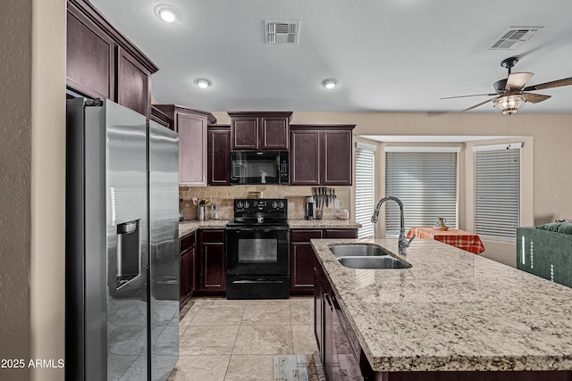 kitchen with a kitchen island with sink, sink, ceiling fan, and black appliances