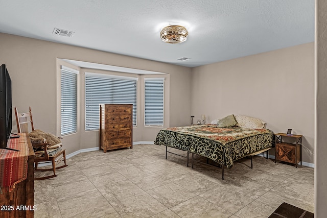 bedroom featuring light tile patterned floors and a textured ceiling