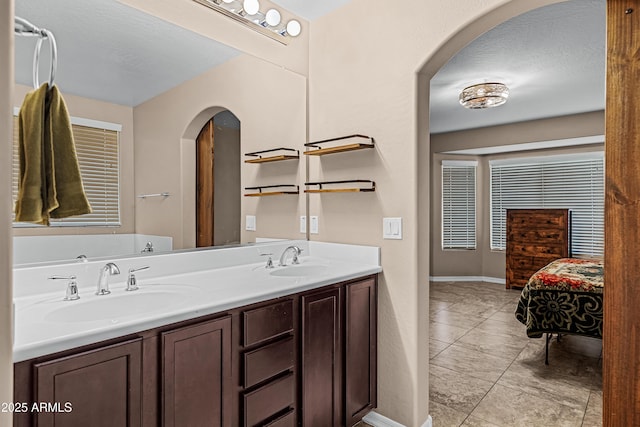 bathroom featuring a textured ceiling, vanity, and tile patterned floors