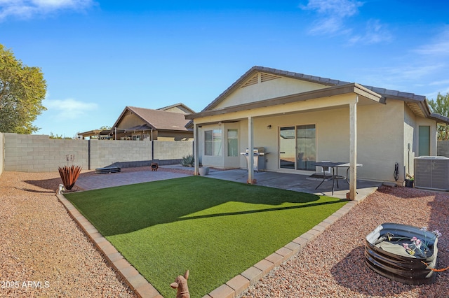 back of house featuring a lawn, central AC, and a patio