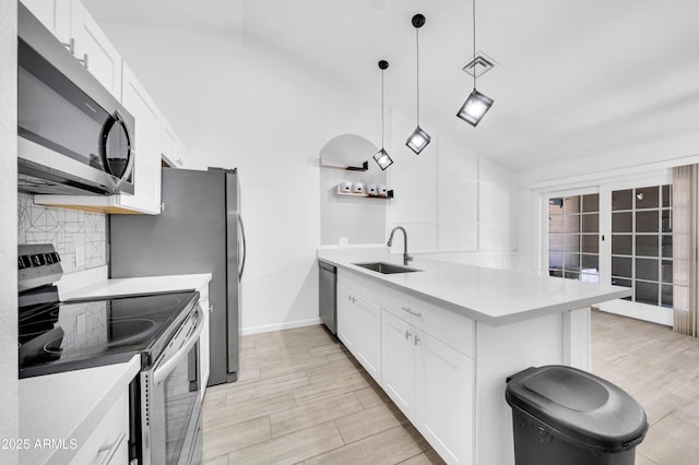 3201 W Mohawk Ln, Phoenix, AZ 85027 - kitchen featuring appliances with stainless steel finishes, a sink, vaulted ceiling, a peninsula, and backsplash
