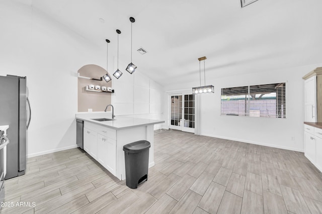 3201 W Mohawk Ln, Phoenix, AZ 85027 - kitchen featuring a peninsula, a sink, wood tiled floors, appliances with stainless steel finishes, and light countertops