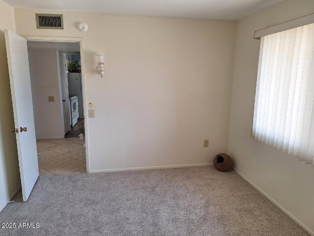 carpeted spare room with baseboards and visible vents