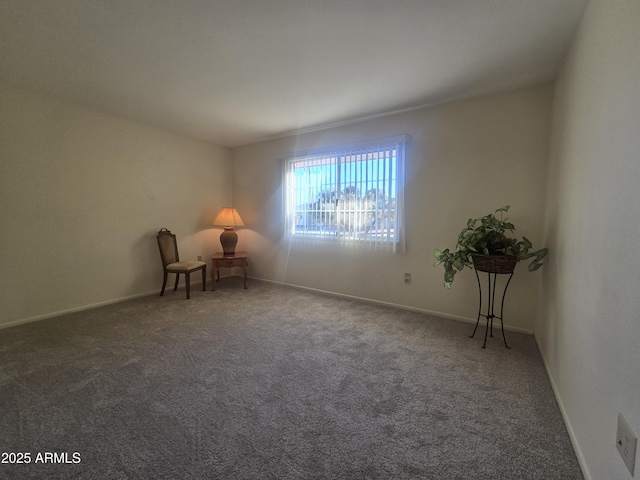 unfurnished room featuring carpet and baseboards