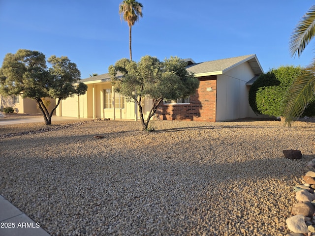 view of front of home with brick siding and a garage