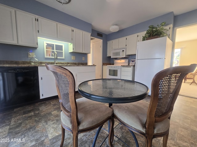 dining area featuring stone finish flooring and visible vents