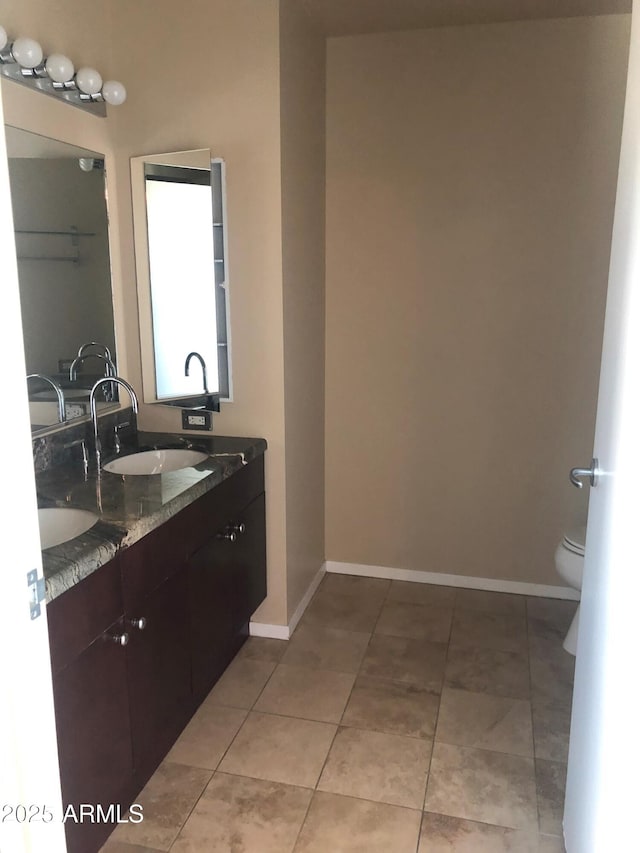 bathroom featuring tile patterned flooring, vanity, and toilet