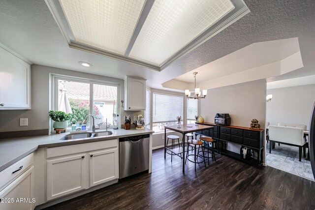 7110 N 28th Dr, Phoenix, AZ 85051 - kitchen featuring dishwasher, a sink, a tray ceiling, a chandelier, and white cabinetry