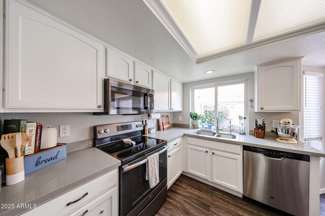 7110 N 28th Dr, Phoenix, AZ 85051 - kitchen featuring stainless steel appliances, a sink, dark wood-style flooring, and white cabinets