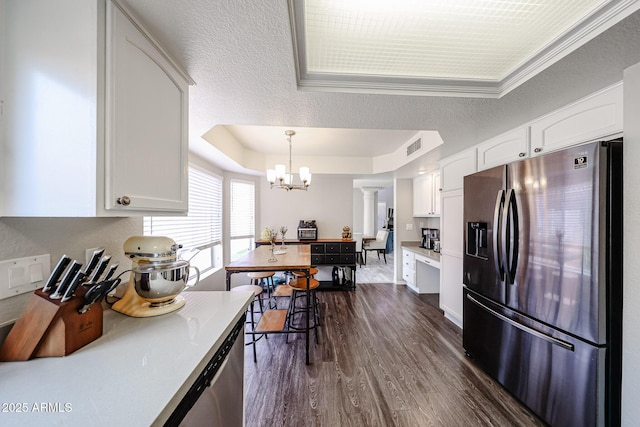 7110 N 28th Dr, Phoenix, AZ 85051 - kitchen with stainless steel appliances, a raised ceiling, white cabinetry, dark wood-style floors, and a chandelier