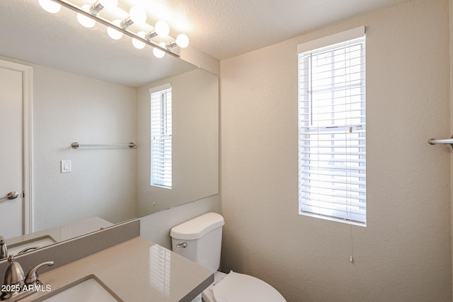 7110 N 28th Dr, Phoenix, AZ 85051 - bathroom with plenty of natural light, toilet, a textured ceiling, vanity, and a textured wall