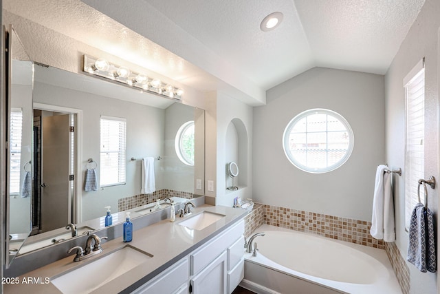 7110 N 28th Dr, Phoenix, AZ 85051 - full bathroom with a bath, a textured ceiling, double vanity, and vaulted ceiling