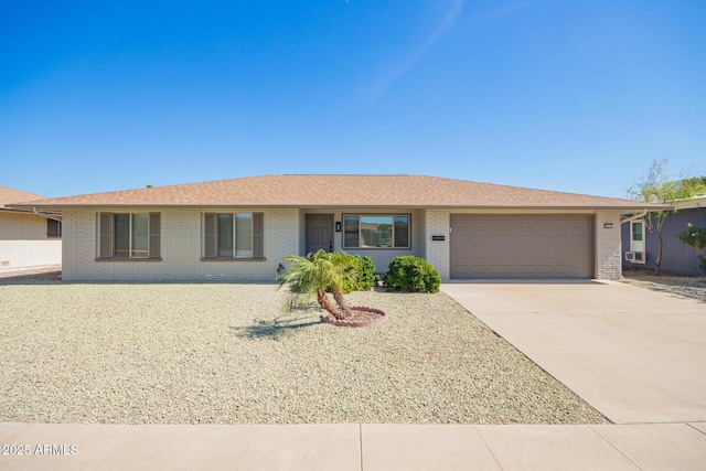 ranch-style house featuring a garage, driveway, and brick siding