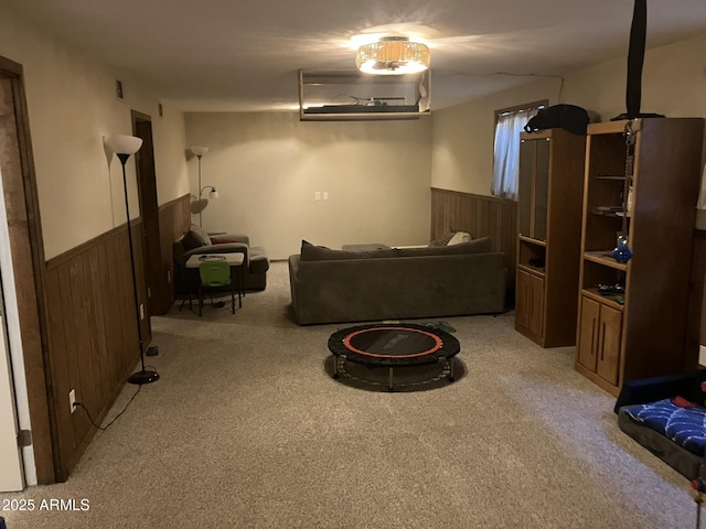 living room featuring wood walls and light colored carpet