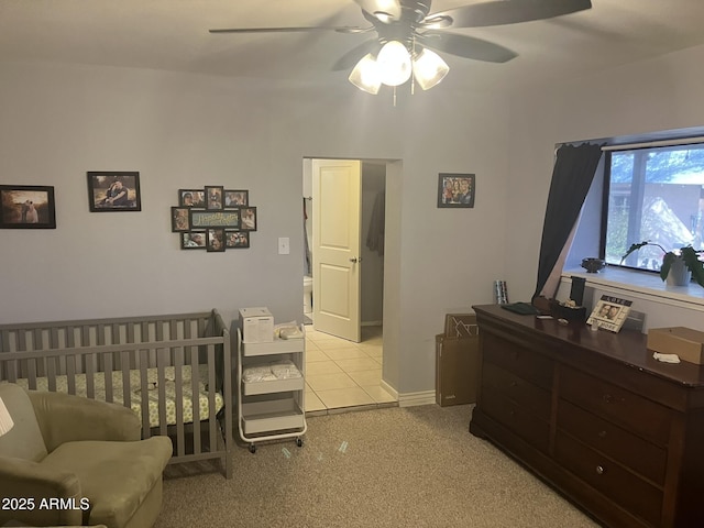 bedroom featuring ceiling fan and a crib