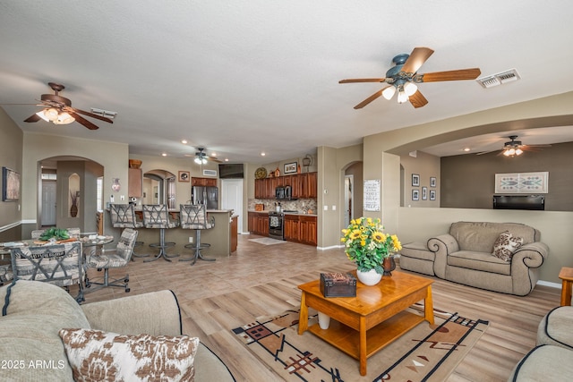 living room with light hardwood / wood-style flooring and ceiling fan