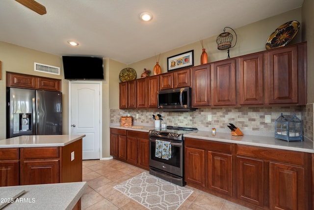 kitchen featuring tasteful backsplash, light tile patterned floors, a center island, and appliances with stainless steel finishes