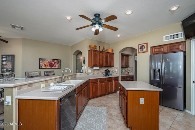 kitchen featuring sink, backsplash, a center island, black appliances, and kitchen peninsula