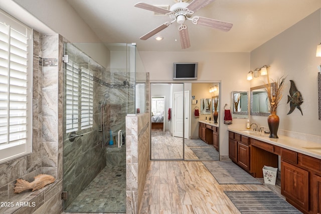 bathroom with vanity, hardwood / wood-style flooring, ceiling fan, and walk in shower