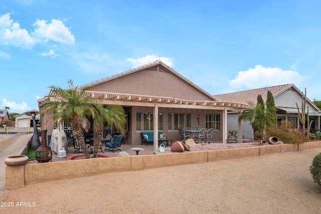 rear view of property with a garage and a patio