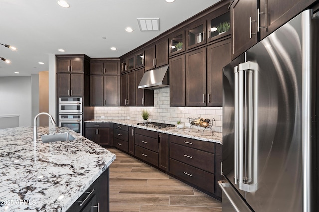 kitchen featuring appliances with stainless steel finishes, dark brown cabinetry, and sink