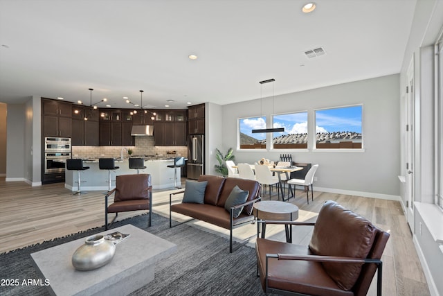 living room with sink and light hardwood / wood-style flooring