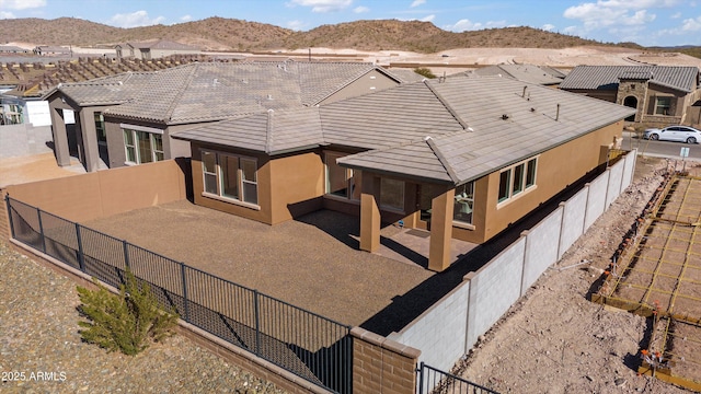 rear view of house with a patio area and a mountain view