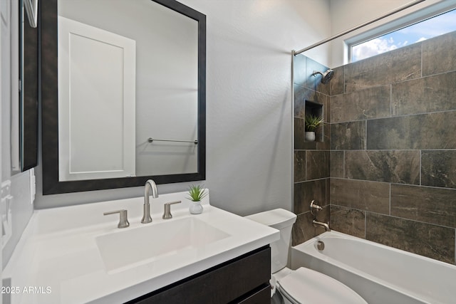 full bathroom with toilet, vanity, and tiled shower / bath