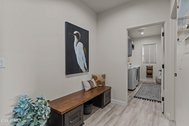 hallway with light hardwood / wood-style floors and washer and clothes dryer