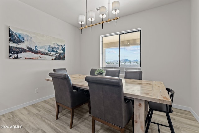 dining space with a notable chandelier and light hardwood / wood-style floors