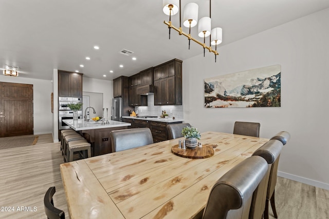 dining room featuring light wood-type flooring and a notable chandelier