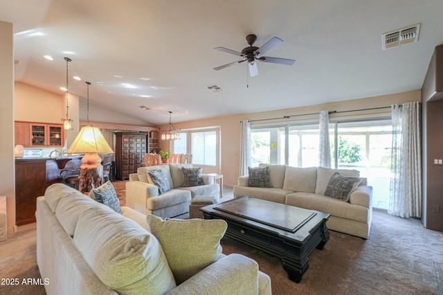 living room with ceiling fan with notable chandelier and vaulted ceiling