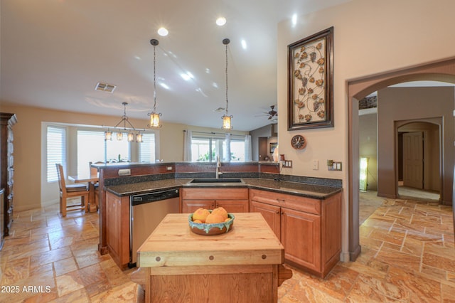 kitchen with stainless steel dishwasher, a kitchen island, pendant lighting, and kitchen peninsula