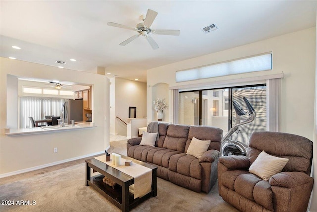 carpeted living room with ceiling fan