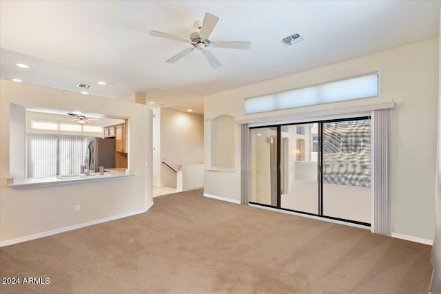 carpeted spare room with ceiling fan and a healthy amount of sunlight