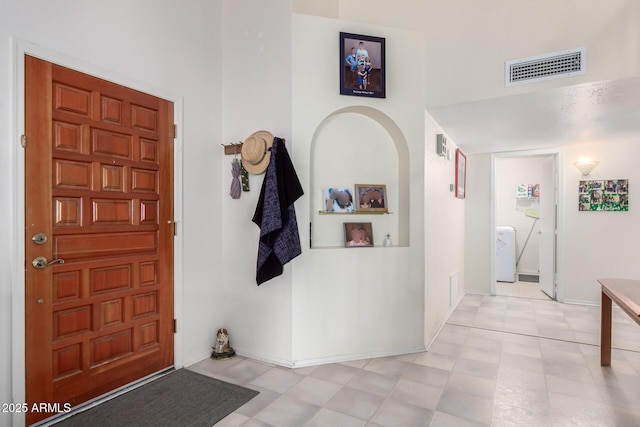 foyer with baseboards and visible vents