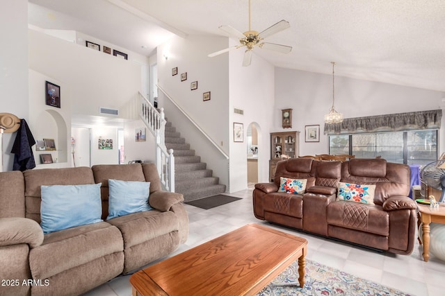 living room featuring light floors, visible vents, stairs, and arched walkways