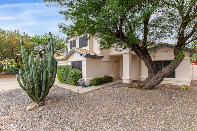 view of front of property featuring a tile roof and stucco siding