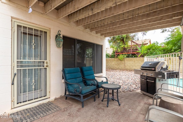 view of patio with a grill and fence