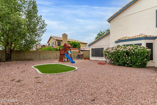 view of yard with a fenced backyard and a playground