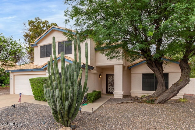 view of front facade with a garage, driveway, a tiled roof, and stucco siding