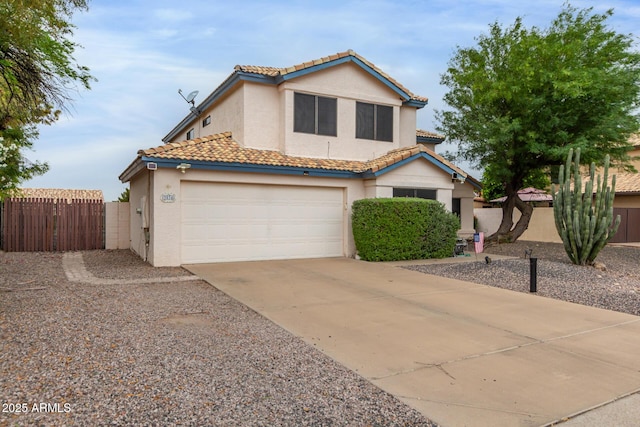 view of front of house featuring a tile roof, fence, concrete driveway, and stucco siding