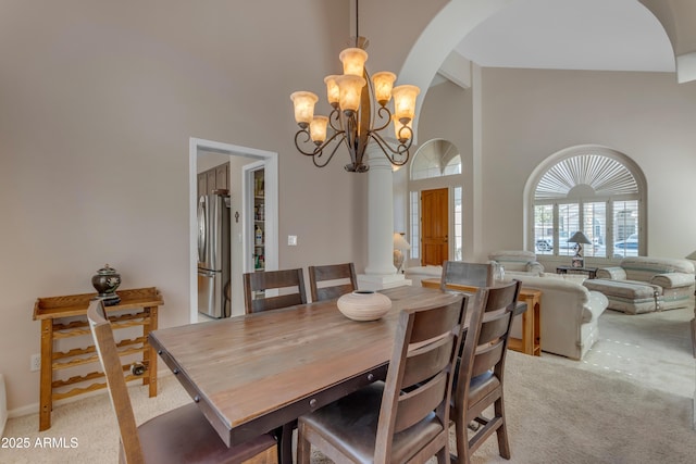 dining area with a chandelier, light carpet, high vaulted ceiling, beamed ceiling, and ornate columns