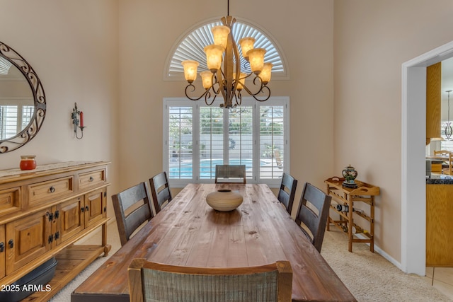 dining space featuring light carpet, baseboards, and a chandelier