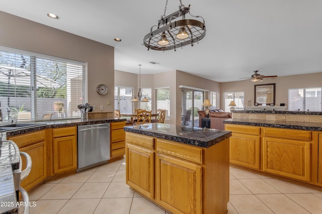 kitchen with light tile patterned flooring, a sink, stainless steel dishwasher, tile counters, and pendant lighting