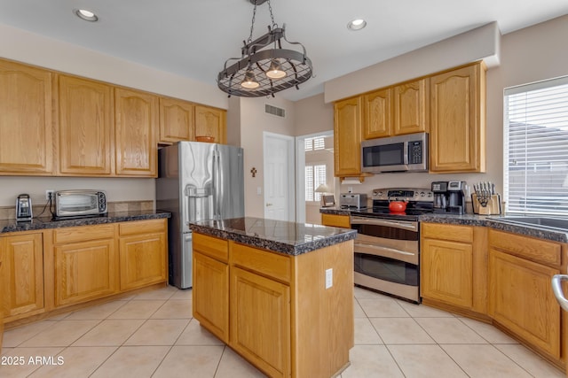 kitchen with light tile patterned floors, visible vents, appliances with stainless steel finishes, and a center island